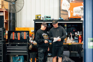 Speedshop technicians reviewing a job sheet